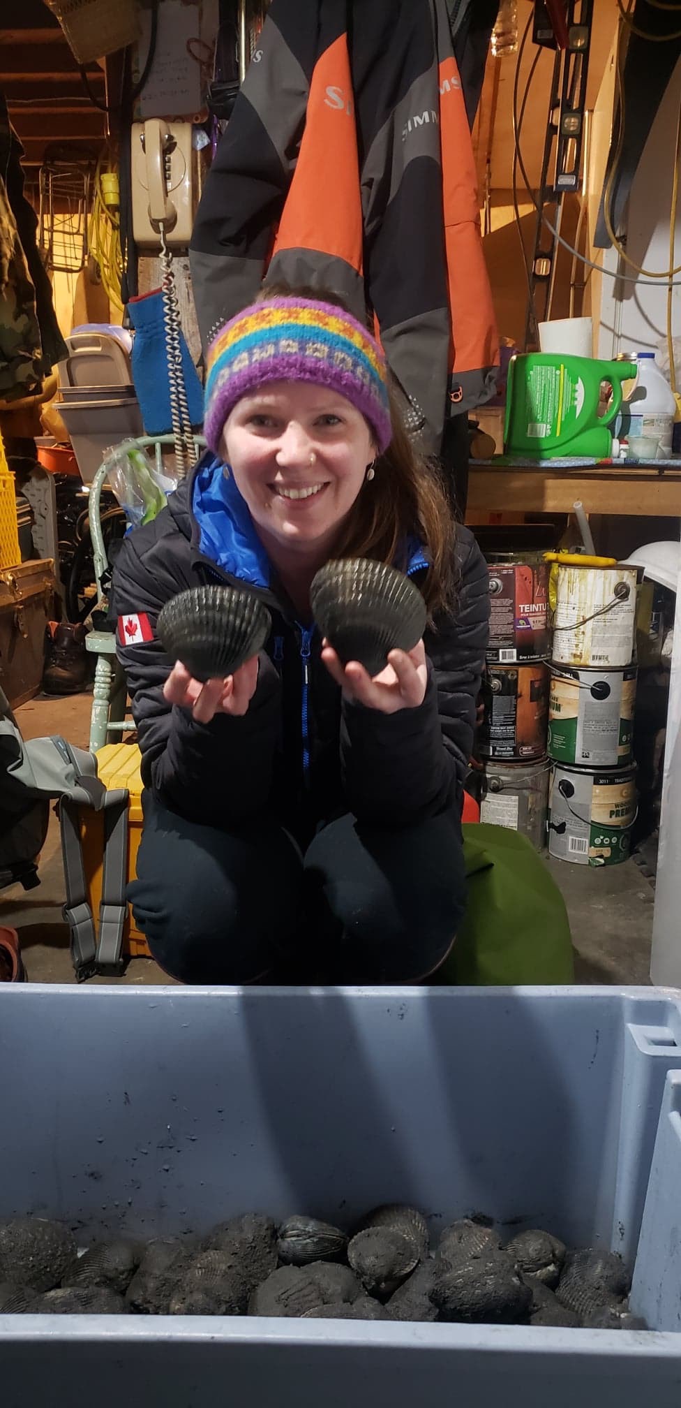 A lady smiling and holding two shells