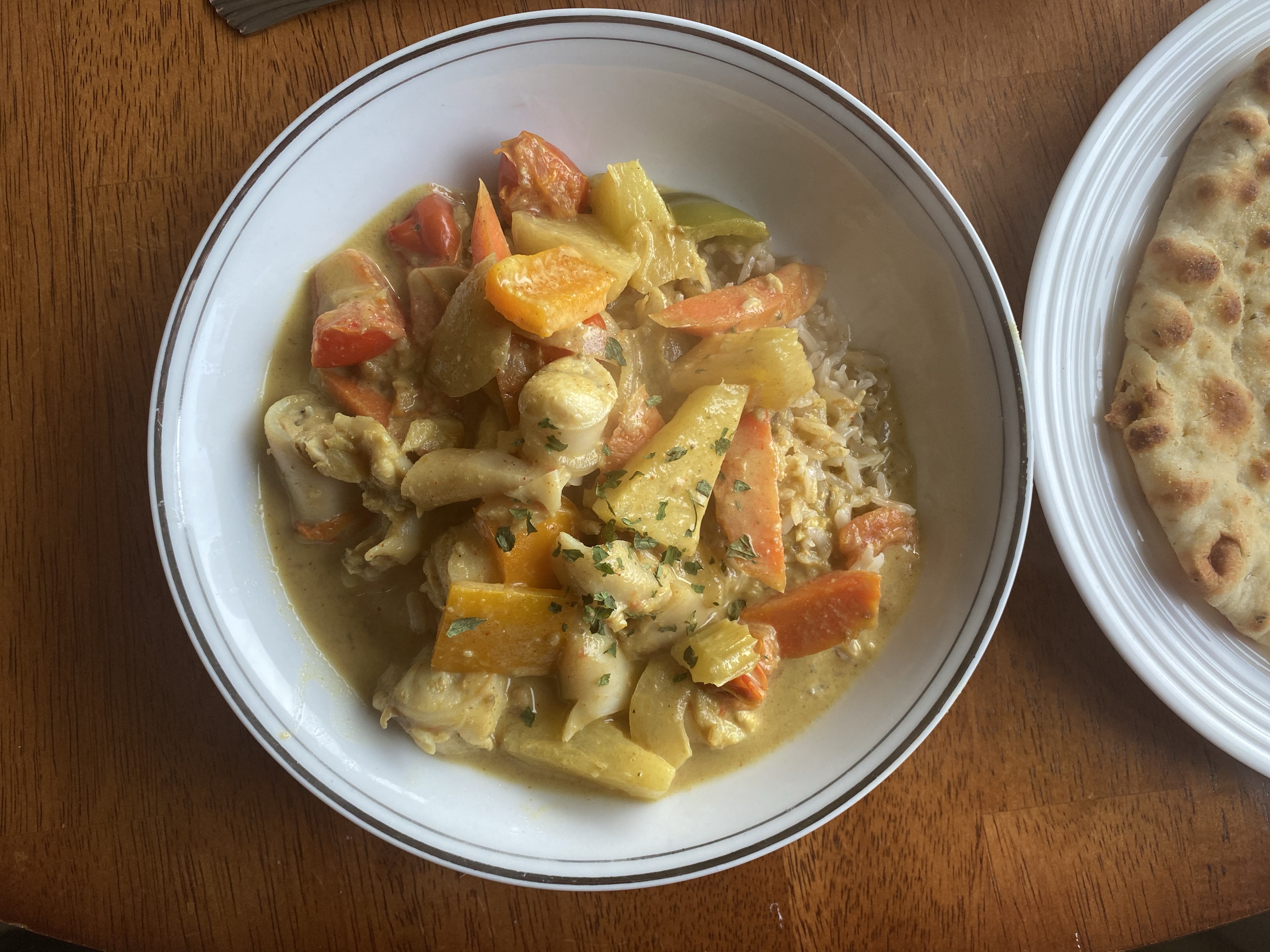 Pineapple G̱a̱boox Curry in the white plate