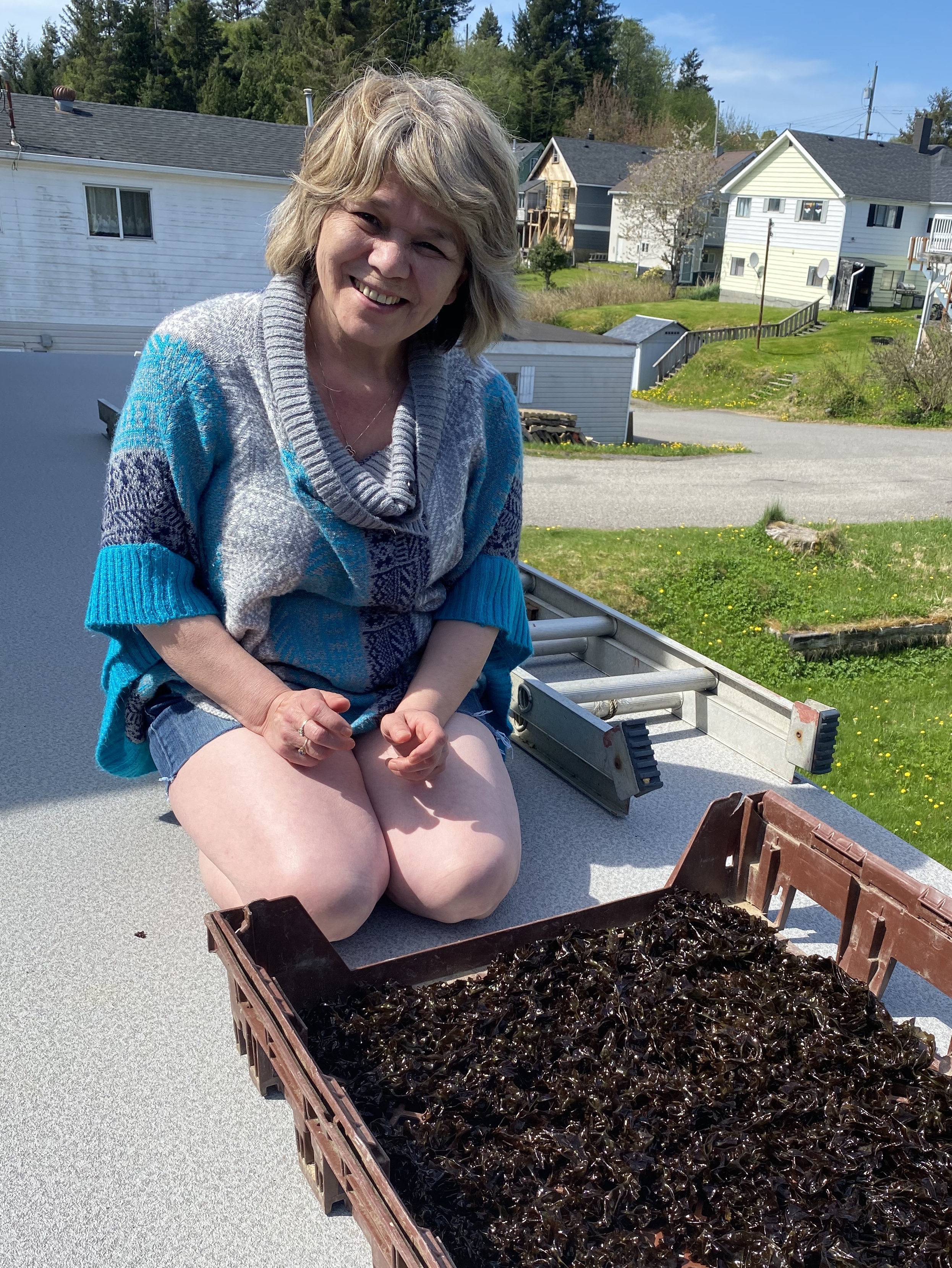 lady smiling infront of dried seaweed outdoors