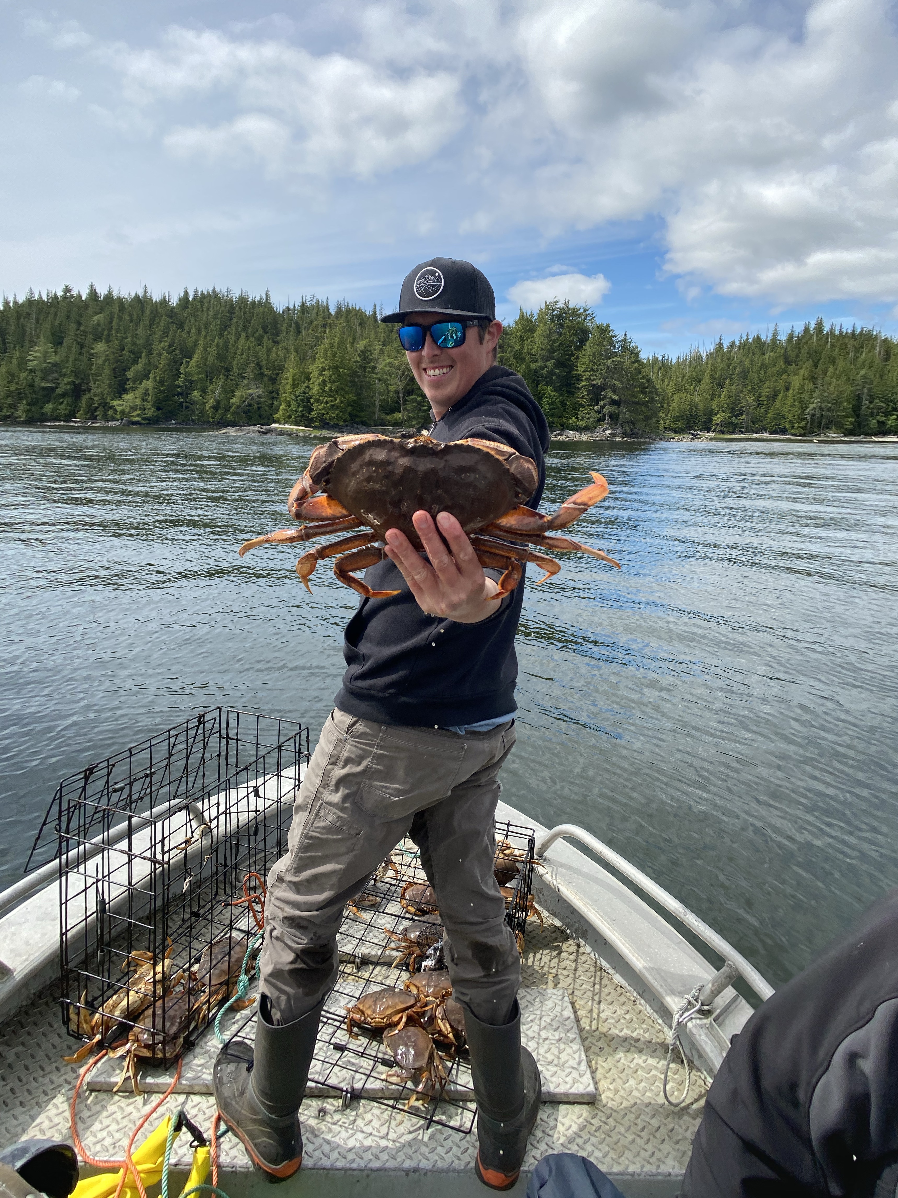 man on a boat holding a ḵ'a̱lmoos - crab