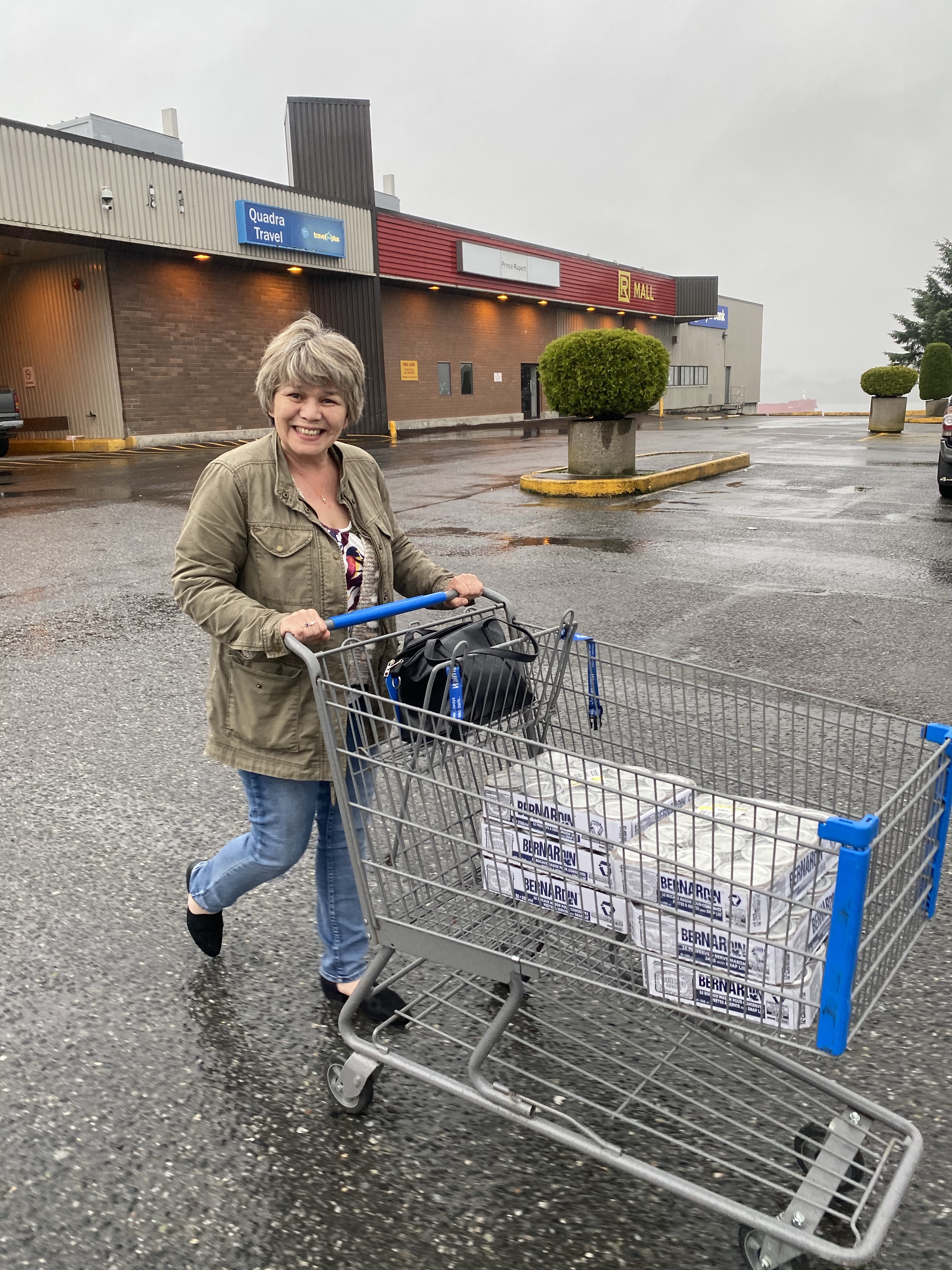 A lady smiling and carrying a cart