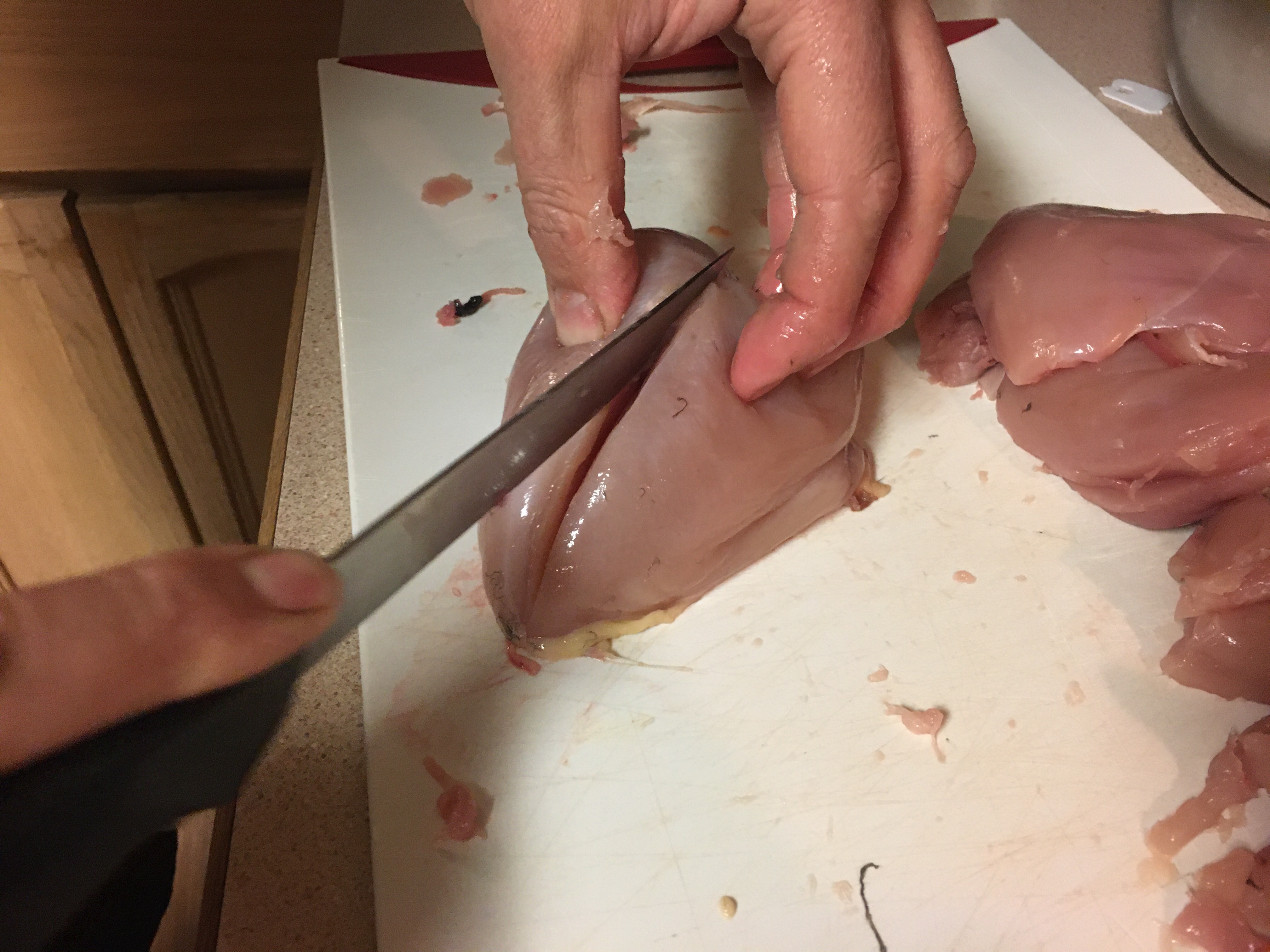 a person cutting a grouse breast