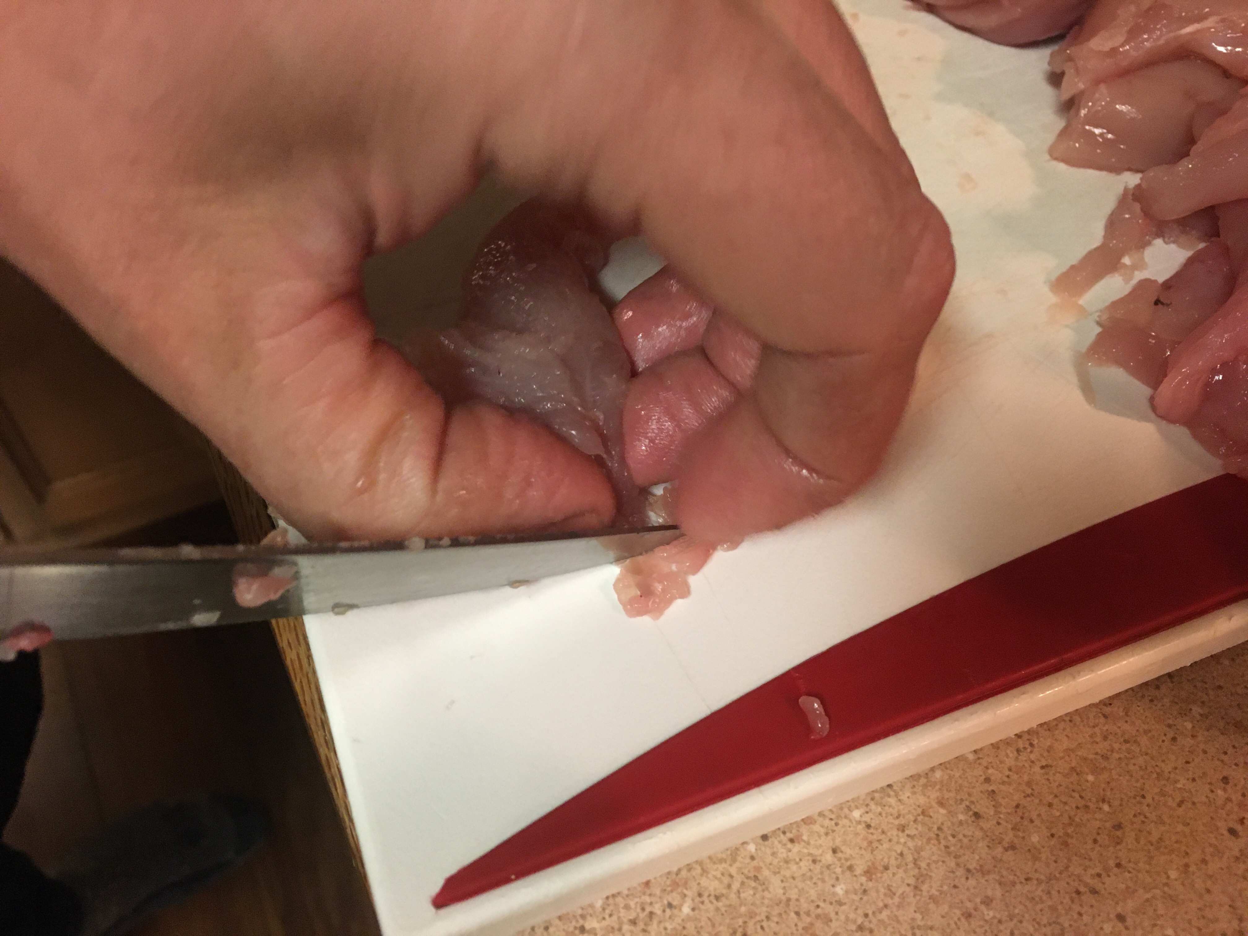 a person separating the tendon from the meat