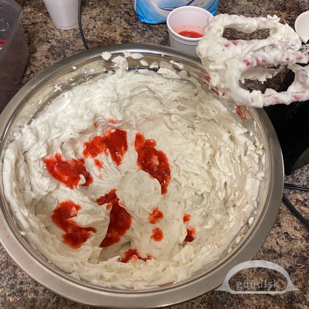 mashed strawberries being added to the yel 'as